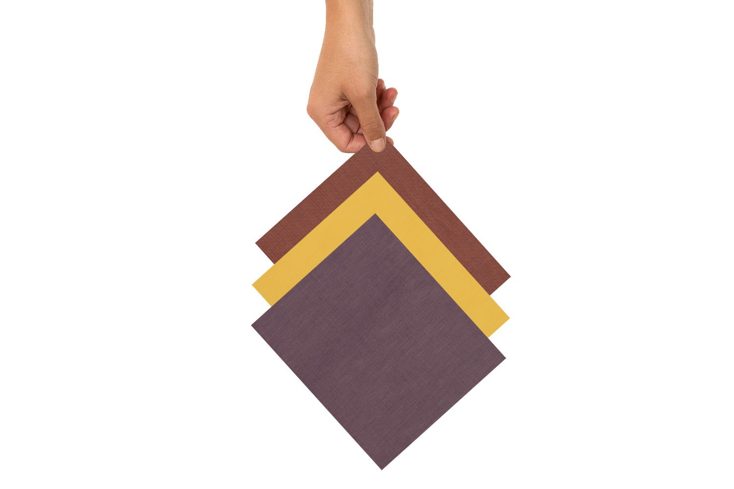 Eine Hand hält drei Bienenwachstücher in den Farben Rot, Gelb und Lila.