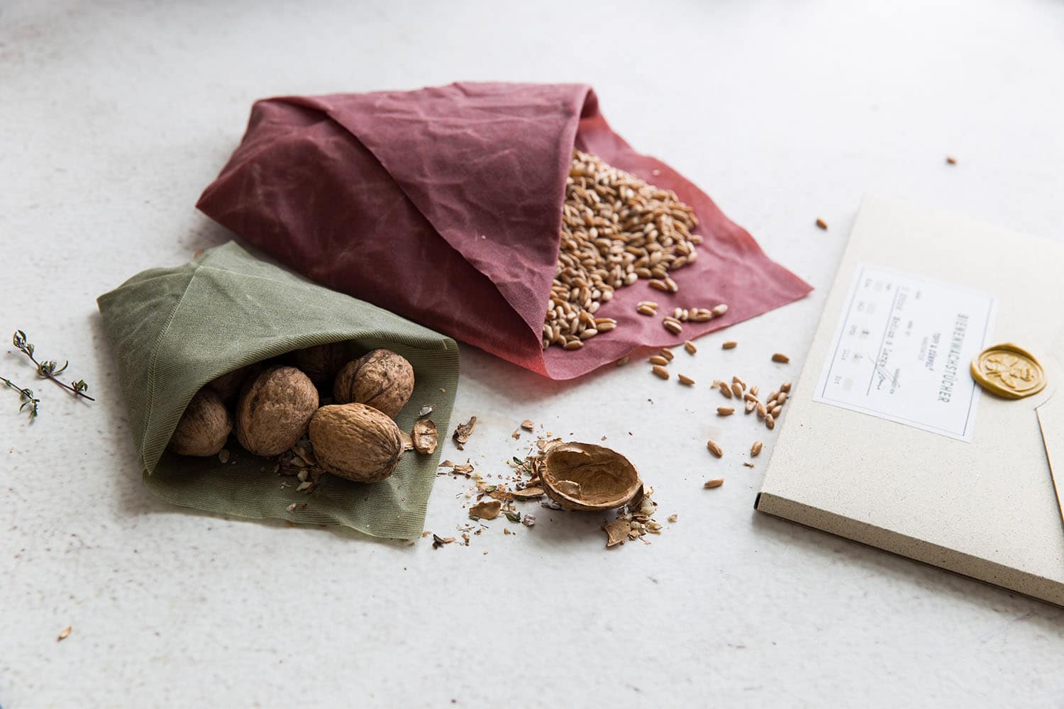 Two beeswax wraps in green and red filled with grain and nuts