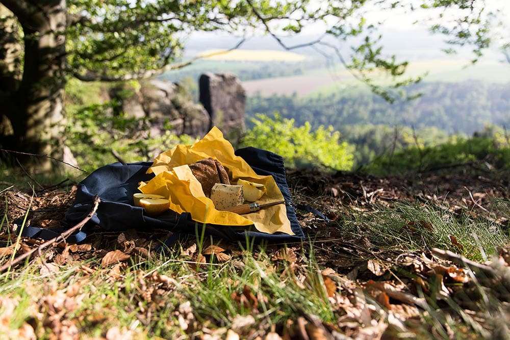 Gelbes Bienenwachstuch mit Brotzeit beim wandern